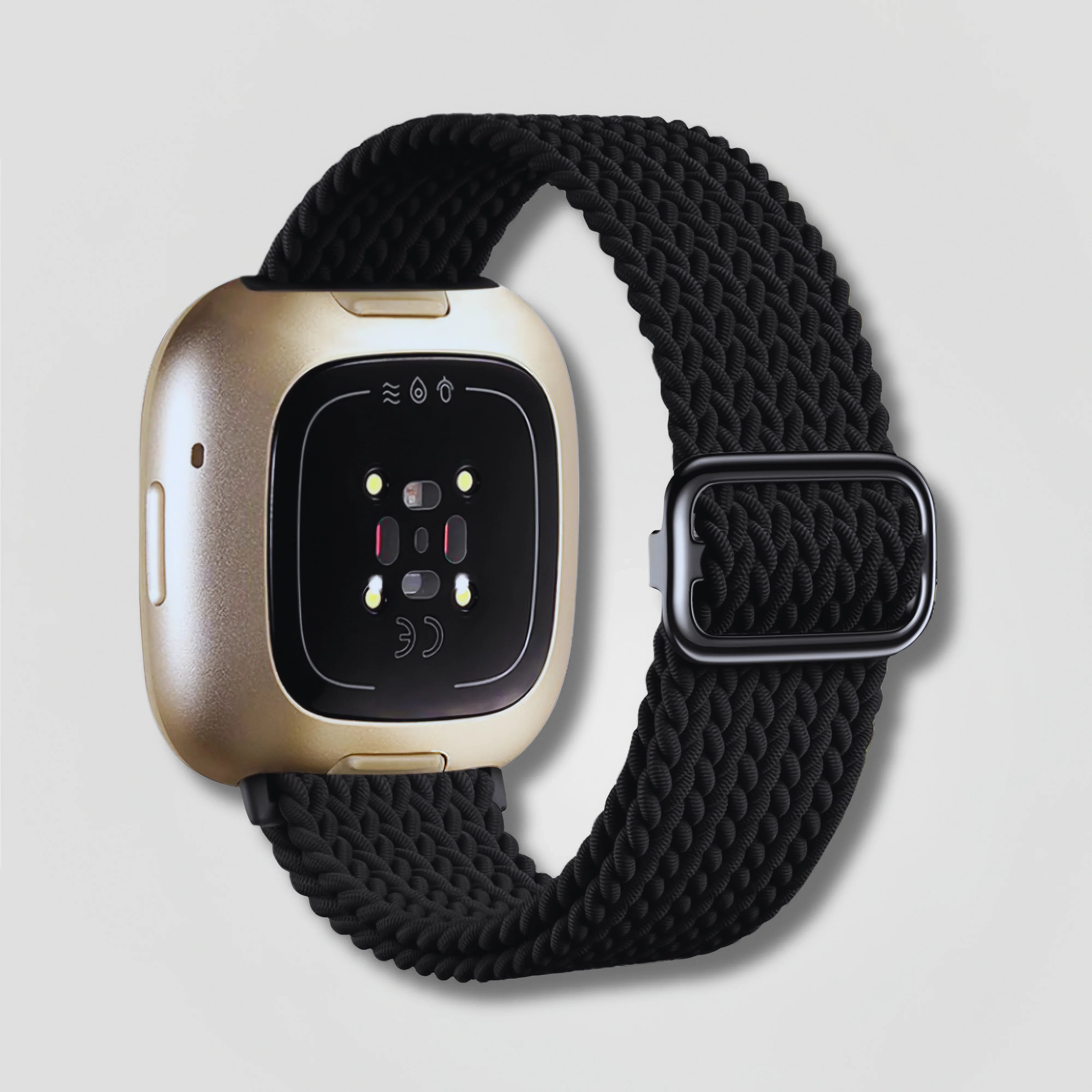 Image of Black braided loop band on gold Fitbit Sense smartwatch, product display on gray background
