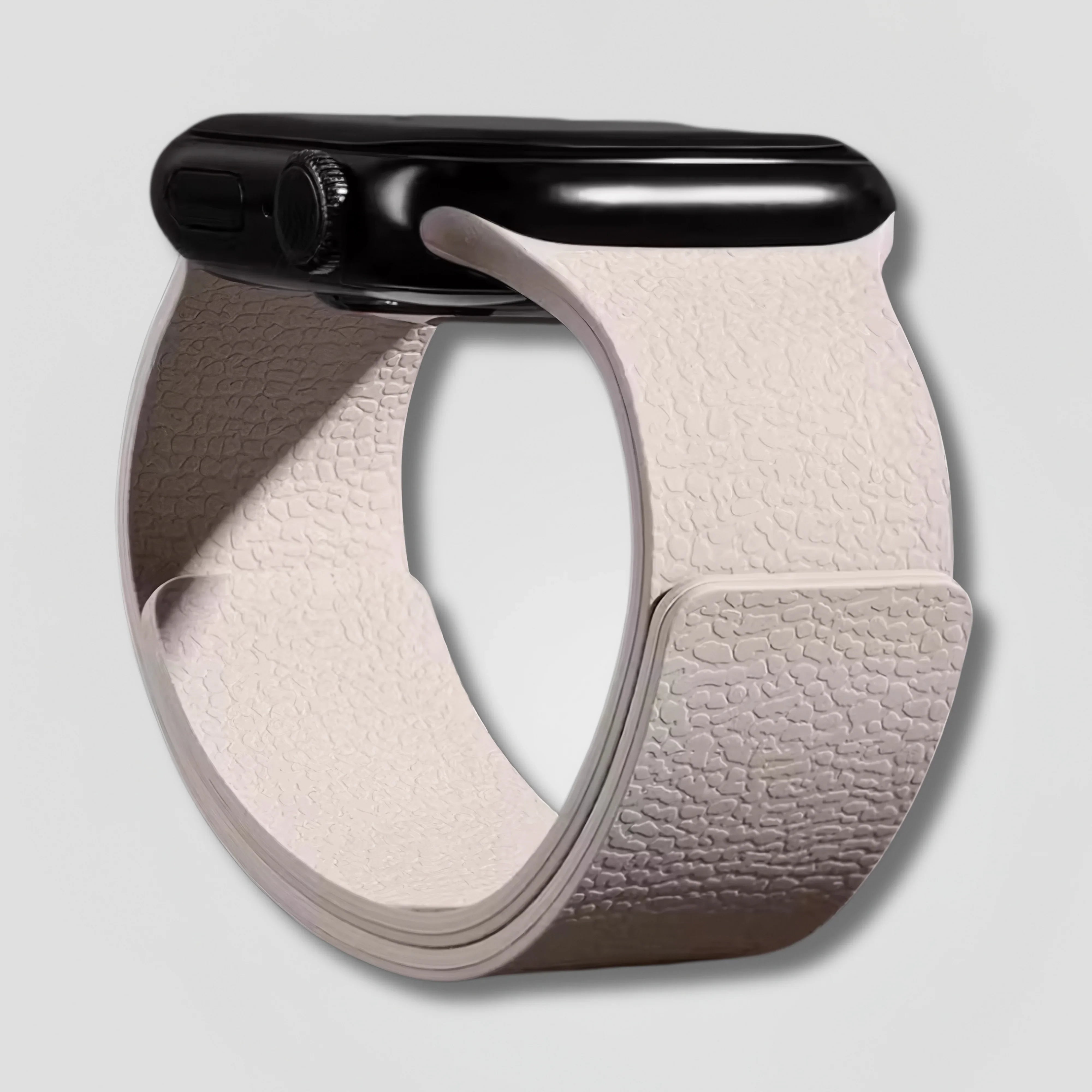 Ivory textured magnetic loop band on black Apple Watch against a plain background